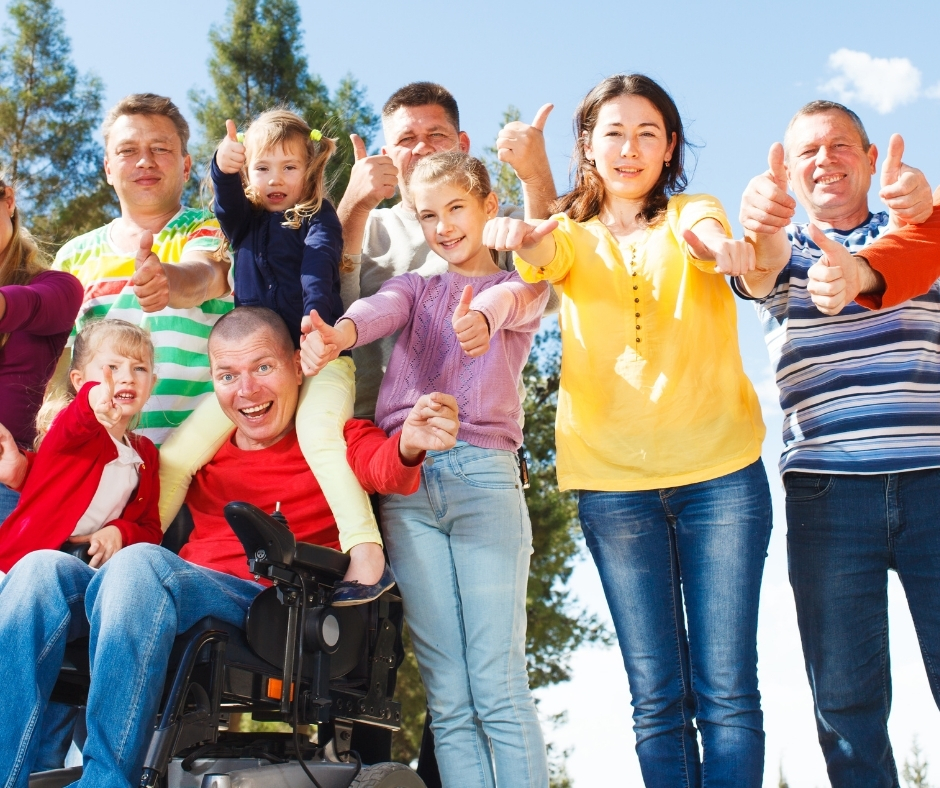 large family surrounding paraplegic man in wheelchair